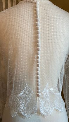 Beautiful off white/pale ivory pointelle topper. Trimmed with cotton embroidered lace at hemline & sleeves. 25 covered buttons enclose the back with button loops. Bust 34/35 Shoulder to shoulder across back 16 Sleeve length (under seam) 16 Biceps 11 Length from shoulder 17 **all fabrics & trims upcycled from other wedding apparel💚 **One of a kind design💕 (fabric swatch available) Long Sleeve Delicate Lace Wedding Night Dress, Feminine Lace Top Wedding Dresses, Long Sleeve Delicate Lace Dress For Wedding Night, Feminine Wedding Gown With Lace Trim, Feminine Lace Gown With Lace Trim, Feminine Lace Gown With Delicate Details, Long Sleeve Lace Gown For Wedding Night, Lace Back Gown For Wedding Night, Lace Long Sleeve Gown For Wedding Night