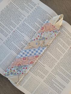 an open book with a piece of fabric on top of it