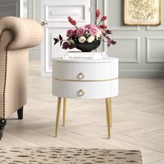 a white table with flowers on it and a chair next to it in a living room