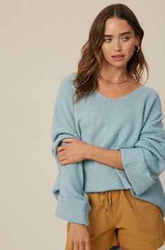 So chic and effortless, this slouchy, oversized tunic-style sweater features a v-neckline and dropped wide sleeves for added shape. -Available in Stone & Misty Blue -Waffle textured -V-neck -Oversized fit -Soft touch eyelash two tone yarn -Long sleeve with folded cuffs -Side slits -Ribbed on hem -Content: 74% Acrylic 22% Polyester 4% Lycra -Hand was cold/Line dry -Imported -Model is 5 8" 32-24-34 and wearing a size Small Oversized Tunic, Tunic Style, Style Sweater, Tunic Styles, Knitted Pullover Sweaters, Wide Sleeves, Oversized Sweater, Sweaters Oversized, Two Tone