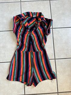 This 1970's striped jumpsuit has a zipper front and cap sleeves with a booty shorts look.  It is missing a belt.  It is an XS but please refer to the size measurements below for an accurate fit.  The hem on the shorts is falling out as shown in pictures. It is in decent condition other than that. I think the fabric is a poly knit but not 100% sure. V-neck(collar to zipper)-6 inches Chest-32 inches Waist-24 inches no pull/26inches with pull Hips-36 Rise-12 inches Inseam-2 inches Sleeve-1 inch Collar point-4 inches Zipper length-13 inches Waist to hem-11 inches To see more of our authentic 1970's vintage clothing inventory please visit our store at ChoiceRecycling.  We add new items every week. Jumpsuit Shorts, Womens Jumpsuits, Vintage Rainbow, Striped Jumpsuit, Short Jumpsuit, Rainbow Stripes, Neck Collar, 11 Inches, Festival Season