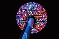 a large colorful light ball on top of a pole