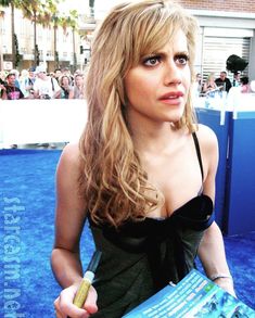 a woman in a black dress holding a blue book