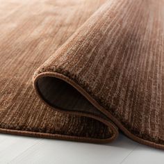 a close up view of a brown rug on the floor with white floors and walls