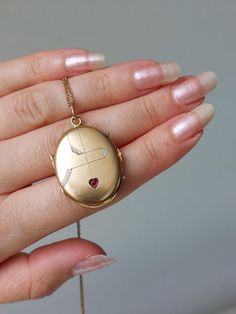 Beautiful and well-preserved Art Nouveau locket with fine engravings and a ruby paste in a heart-shaped inlay. It has a rosy gold color and semi-matte finish. Details: The locket dates from the Art Nouveau era, 1900s. It is not stamped and likely made of a gold plated metal. Condition: The locket is in excellent antique condition, with only very gentle surface wear and scratches. No dent. Inside one of the original rings and celluloid covers are present. It closes tightly with a snap. The bale i Heirloom Oval Jewelry For Valentine's Day, Antique Heart-shaped Yellow Gold Jewelry, Collectible 14k Gold Heart-shaped Jewelry, Victorian Locket Jewelry For Valentine's Day, Victorian Locket For Valentine's Day, Victorian Yellow Gold Jewelry For Valentine's Day, Heirloom Engraved Jewelry For Valentine's Day, Valentine's Day Engraved Medallion Jewelry, Victorian Medallion Jewelry For Valentine's Day