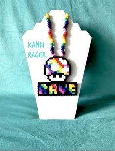 a necklace with an image of a mushroom on it and the words kandi rager above it