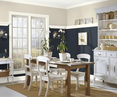 a dining room with blue walls and white furniture