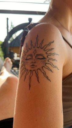 a woman with a sun tattoo on her arm