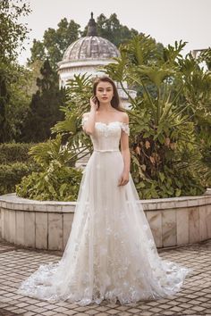 a woman in a wedding dress is standing outside