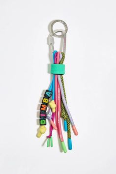 a bunch of different colored toothbrushes hanging from a keychain on a white background