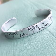 "If the grandmother in your life has a lot of grandkids, then this cuff is the perfect gift for her! The 3/8\" copper or aluminum cuff is hand stamped with all the up to 12 names. A small heart separates each name. After hand stamping each cuff, I harden and polish it, then protect it with a micro-crystalline wax finish. **Please choose COPPER or ALUMINUM, along with the size for your cuff in the drop-down menu to the right. **In Notes To Seller at Checkout, please write the CHILDREN'S NAMES you Grandma Jewelry, Grammy Gift, Gigi Gift, Mimi Gift, Personalized Bracelet, Jewelry Personalized, Nana Gifts, Gift For Grandma, Personalized Bracelets