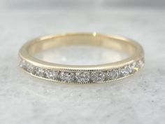 This engraved band is of a perfect heft and shape to feel soft and pleasant on the finger. It is both pretty and sophisticated, and it would be a great wedding band for a woman who wants a little extra sparkle but works with her hands. The fine color and quality of the diamonds paired with the engraving truly sets this band apart. Metal: 14K Yellow Gold Diamonds: 12 diamonds weighing approx. .48 carats, G in Color, SI1 in Clarity Measures: 2.6mm (W) x 1.75mm (H) Size: 6 (but can be sized to fit Classic White Gold Diamond Ring With Decorative Band, Classic Engraved Ring With Round Band For Marriage, Classic Rings With Decorative Band For Marriage, Timeless Engraved Ring With Classic Design For Wedding, Classic Rings With Decorative Band, Classic Diamond Ring With Decorative Band For Formal Events, Classic Engraved Round Band Ring For Marriage, Classic Marriage Rings With Decorative Band, Timeless Classic Engraved Ring For Wedding