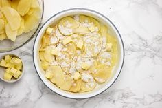 a bowl filled with sliced pineapple next to another bowl full of chopped pineapple