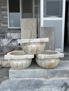 three white marble bowls sitting on top of each other in front of a door way