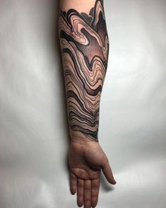 a man's arm with an abstract tattoo on it