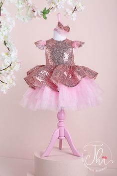 A rose gold tutu princess dress which has cap sleeve, feathers on arms, sequin fabric top, and pink layered skirt. Princess Style Sequin Dress With Glitter Tulle, Pink Sequin Dress For Dress-up, Pink Glitter Sequin Dress For Dress-up, Pink Sparkly Sequin Dress For Dress-up, Princess Style Sequined Tutu Dress, Pink Princess Dress With Sequins For Wedding, Pink Sequin Princess Dress For Wedding, Princess Style Tulle Sequin Dress For Dress-up, Embellished Glitter Tulle Princess Dress