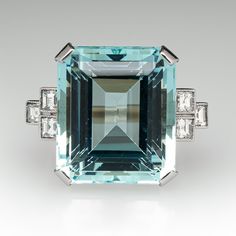 This fantastic vintage aquamarine ring is centered with one (1) emerald cut natural aquamarine set into a four-prong setting. The shoulders of the ring are each accented with three (3), bezel set, square step cut diamonds, bordered with milgrain edging. The ring measures 18.5mm at the top, rises 11.4mm above the finger, tapering to 2.2mm wide and 1.0mm thick at the base of the shank. The ring is currently a size 6.5. Formal Rectangular Emerald Ring With Center Stone, Formal Emerald Ring With Diamond And Rectangular Stone, Formal Emerald Ring With Rectangular Diamond, Luxury Rectangular Emerald Ring With Center Stone, Fine Jewelry Emerald Ring With Rectangular Stone For Formal, Formal Emerald Ring With Gemstone Accents, Formal Turquoise Aquamarine Jewelry, Modern Octagon Emerald Ring For Formal Occasions, Formal Emerald Cut Topaz Ring With Gemstone Accents