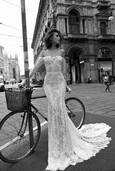 a woman standing next to a bike on a street