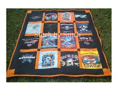 an orange and black quilt on the grass with many t - shirts printed on it