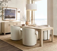 a dining room table with white chairs and a large window overlooking the ocean in front of it