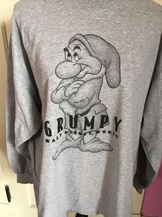 "Vintage 1990's Y2K long sleeve Tee Shirt with *GRUMPY* on it. Gray in color. Made of 90% Cotton and 10% Polyester. Tagged size XL. Go by the measurements below. *MORE INFORMATION BELOW* CONDITION: No issues noted. MEASURES: Chest/Bust~48\" Bottom edge~52\" Sleeve length~21\" Shoulder seam to shoulder seam~23\" Back of collar to bottom~29\" *WE APOLOGIZE~BUT WE NO LONGER SHIP TO GERMANY, ITALY OR SPAIN. IF ORDERS COME IN FROM GERMANY, ITALY OR SPAIN, WE WILL HAVE TO CANCEL THEM AND REFUND YOUR M 90s Graphic Print Long Sleeve T-shirt, Vintage Long Sleeve T-shirt For Winter, Retro Gray Long Sleeve Tops, 90s Long Sleeve Graphic T-shirt, Winter Long Sleeve Graphic Shirt, Retro Long Sleeve Pre-shrunk Sweatshirt, 90s Long Sleeve Shirt For Streetwear, 90s Style Long Sleeve Shirt For Streetwear, Casual Long Sleeve Pre-shrunk Shirt