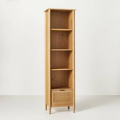 a tall wooden shelf with wicker baskets on the front and bottom shelves, against a white background