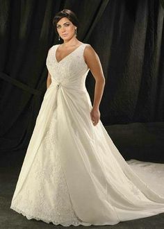 a woman in a wedding dress posing for the camera