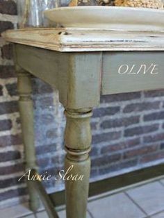 an old wooden table with a white bowl on it