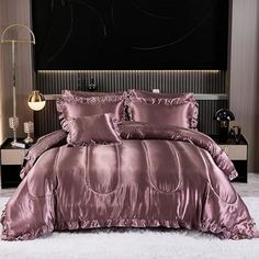 a bed with a purple comforter and pillows