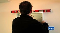 a man is looking at the wall in front of an open box with magnets on it