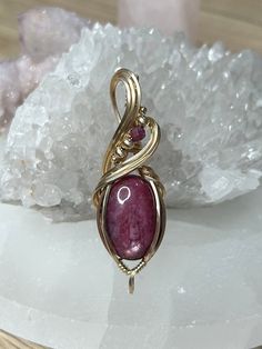 Ruby 14k Gold Filled Wire Wrapped Pendant, complete with a luxurious 22" adjustable necklace. Harnesses the remarkable healing powers of Ruby, a gemstone celebrated for its ability to foster courage, improve energy levels, and promote emotional vitality. This exquisite piece not only enhances your wardrobe but also serves as a beacon of passion and protection. Ideal for daily wear or special occasions, our pendant invites you to experience the joy and empowerment of Ruby's vibrant energies. This Wire Wrapped Yellow Gold Pendant Jewelry, Yellow Gold Wire Wrapped Pendant Jewelry, 14k Gold Spiritual Round Pendant Jewelry, Gold Sterling Silver Jewelry With Cabochon, Spiritual 14k Gold Round Pendant Jewelry, Spiritual 14k Gold Round Pendant, Spiritual 14k Gold Jewelry For Anniversary, Spiritual Birthstone Pendant Jewelry, Formal Yellow Gold Wire Wrapped Jewelry