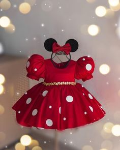 a red dress with white polka dots and a minnie mouse head on it's chest