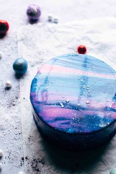 a round object sitting on top of a table covered in bubbles and marbles,