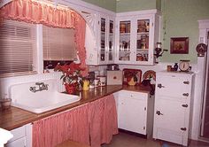 an old fashioned kitchen with white cabinets and wood counter tops is pictured in this photograph