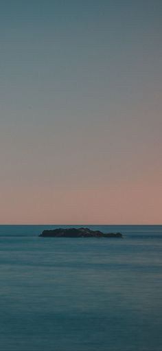 an island in the middle of the ocean at sunset or dawn with no one on it