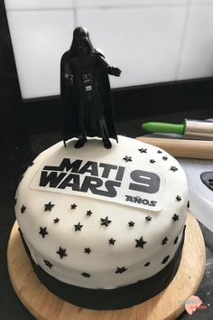 a star wars themed cake with a darth vader figurine on top