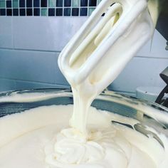 a mixer mixing white cream in a bowl