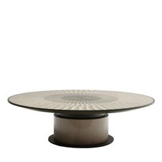 a round glass table with an intricate design on the top and base, against a white background