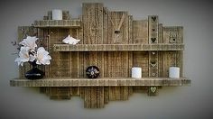 a wooden shelf with flowers and candles on it