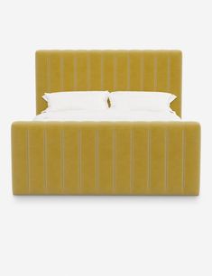 a bed with a yellow headboard and two pillows on it's sides, in front of a white background