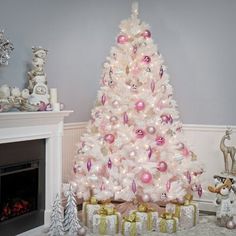 a white christmas tree with pink and gold ornaments in front of a fire place filled with presents