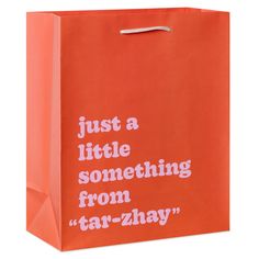 a red shopping bag with the words just a little something from tat - zhay on it