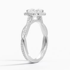 a white gold engagement ring with an oval shaped center stone and pave set shoulders