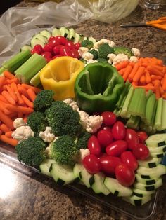 a platter filled with lots of veggies on top of a counter