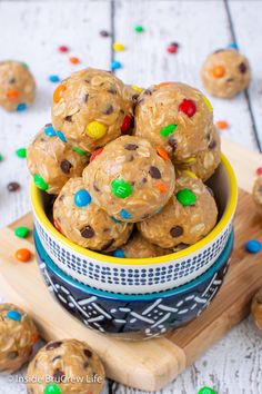 a bowl filled with chocolate chip cookie doughnuts on top of a wooden cutting board