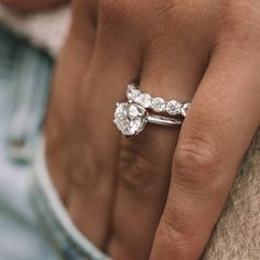 a close up of a person's hand holding a diamond ring