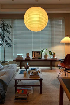 a living room filled with furniture and a large window covered in shades of white paper