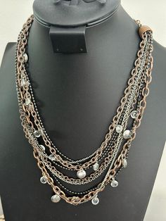 Add some flair to your jewelry collection with this stunning Lia Sophia 'Hotspot' necklace. The piece features nine chains layered together in a unique and eye-catching design. The necklace is made of high-quality copper and silver-tone metal which gives it a stylish and modern look.  This necklace is perfect for any occasion, whether you're dressing up for a night out or adding a touch of elegance to your everyday wear. The Lia Sophia brand is known for its high-quality jewelry, and this necklace is no exception. With its intricate design, it's sure to be a conversation piece and a staple in your jewelry collection. Silver Multi-strand Metal Chain Necklace, Multi-strand Silver Chain Necklace, Layered Multi-strand Metal Jewelry, Silver Chain Metal Necklaces For Layering, Layering Silver Chain Metal Necklaces, Silver Chain Jewelry With Copper Material, Layered Multi-strand Chain Necklace For Party, Layered Metal Chain Necklace For Gift, Metal Beaded Chain Necklaces For Layering