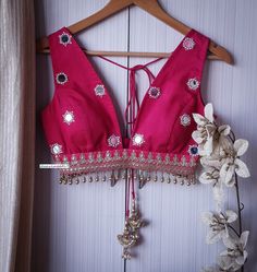 This Made to Order/Made to Measurement/Custom Made Indian Ethnic Blouse. - Fabric - Silk with mirror motifs - Color - Deep Rani Pink - Padded - Princess Cut - Plunge Neckline - Rich lining  - Sleeveless - Embroidered Border - Fringes around the waist - Shoulder string with tassels PLEASE NOTE: BUYERS ARE RESPONSIBLE FOR ANY CUSTOMS AND IMPORT TAXES THAT MAY APPLY. This is a made to order product. If you opt for 'Made To Measurement Option', we will provide a measurement template and you can shar Navratri V-neck Mirror Work Sets, Bollywood Style V-neck Blouse With Mirror Work, Traditional V-neck With Mirror Work, Traditional Wear With Mirror Work And V-neck, Traditional V-neck Wear With Mirror Work, Bohemian V-neck Unstitched Choli, V-neck Wedding Choli With Mirror Work, Traditional V-neck Cutdana Choli, Traditional V-neck Choli With Cutdana