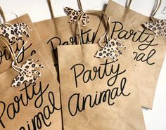 three brown paper bags with black writing on them, one has a cheetah print